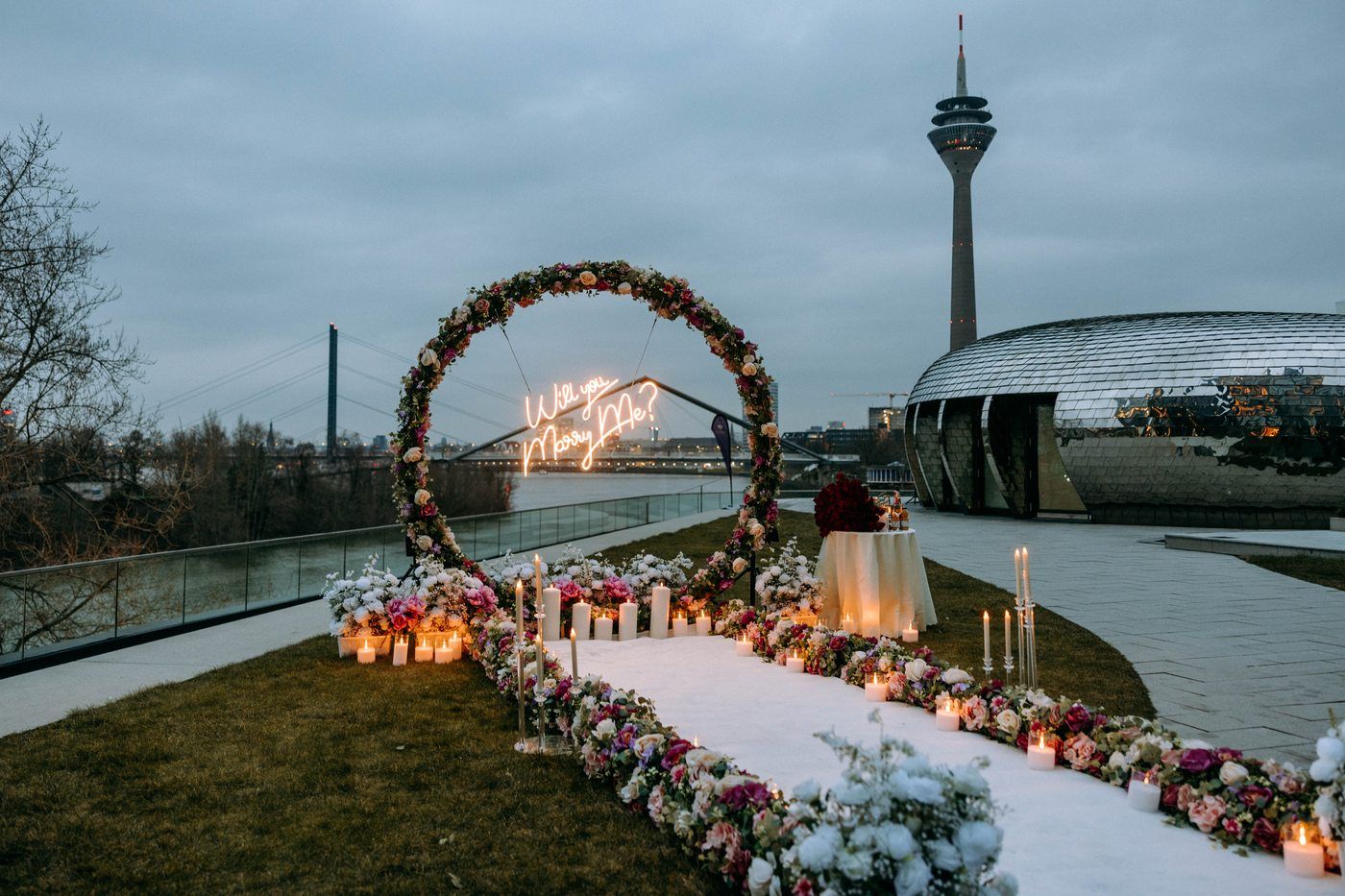 The Flower Magic – Kreisbogen aus bunten Rosen mit Will you Marry Me? Neon am Rheinturm Düsseldorf