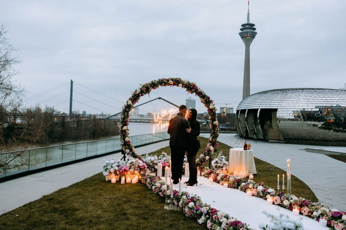 Heiratsantrag Düsseldorf – Rheinturm Blumenbogen mit Neonschild