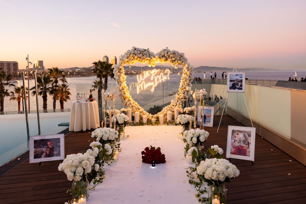 Heiratsantrag Barcelona – Rooftop weißes Rosen-Herz Sonnenuntergang Meer