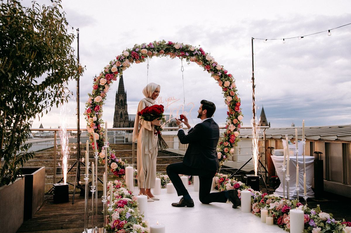 Heiratsantrag Köln Dom Rooftop bunter Blumenbogen Feuerwerk