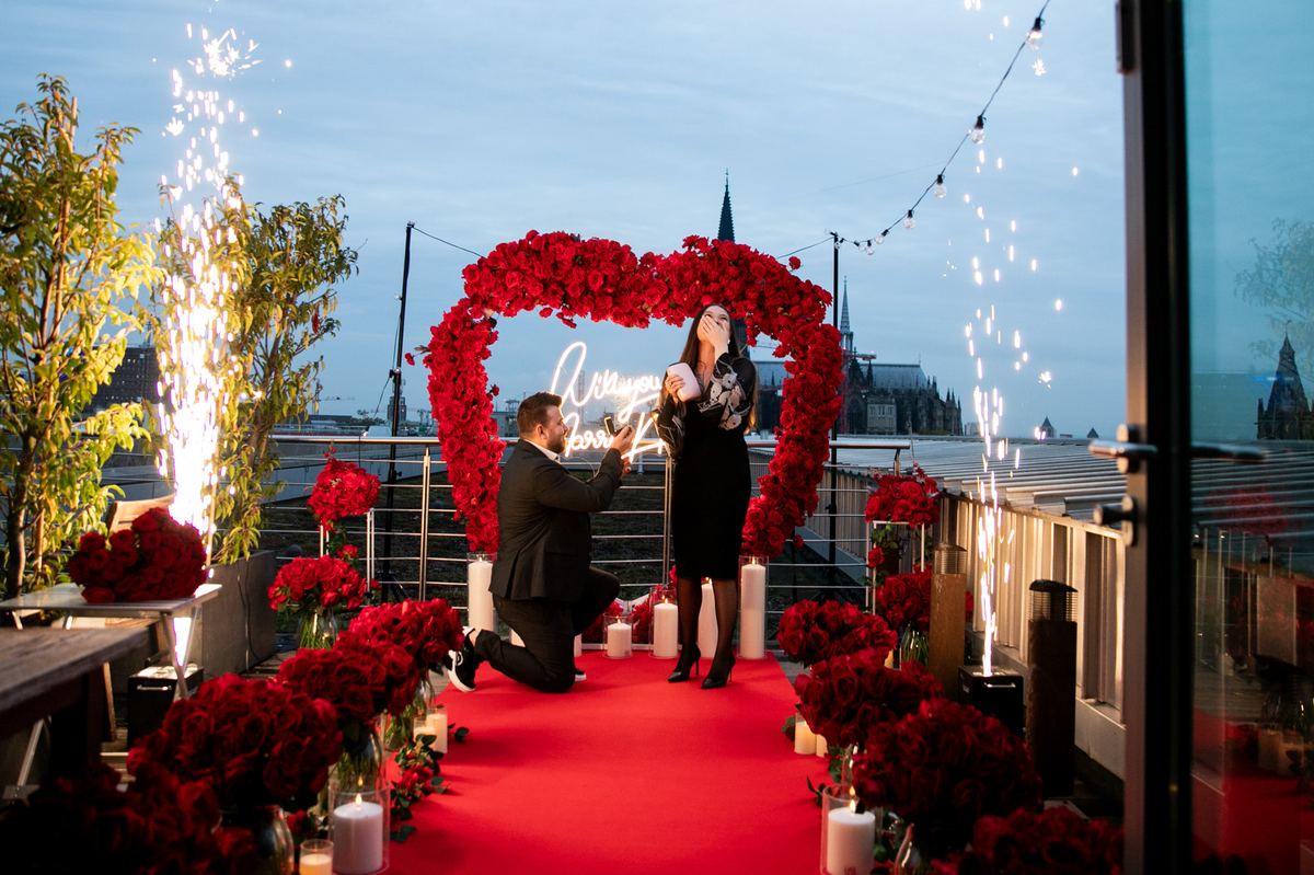 Heiratsantrag Köln Dom Rooftop rotes Rosen-Herz Feuerwerk Kniefall